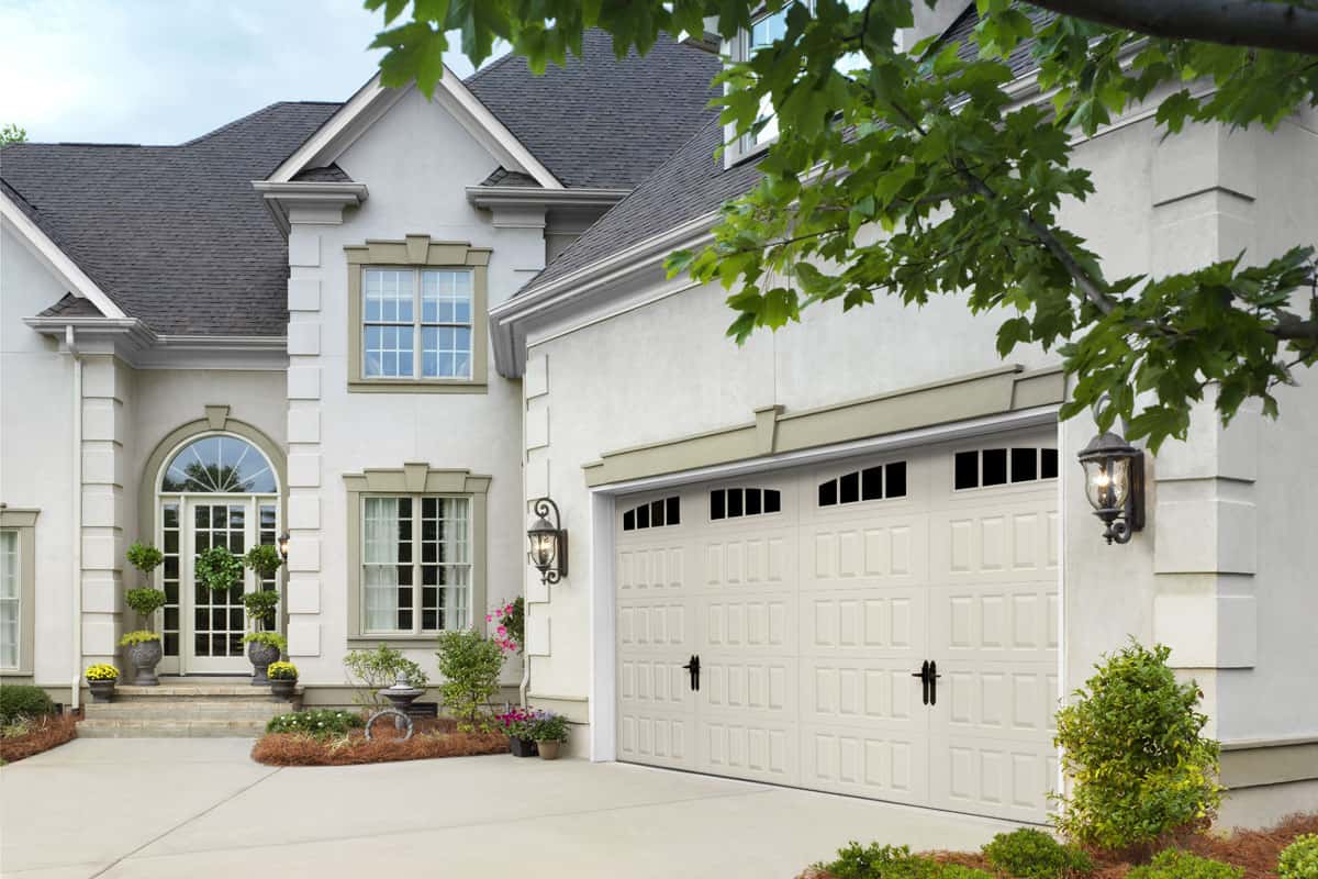 White house with a garage door that has raised panels