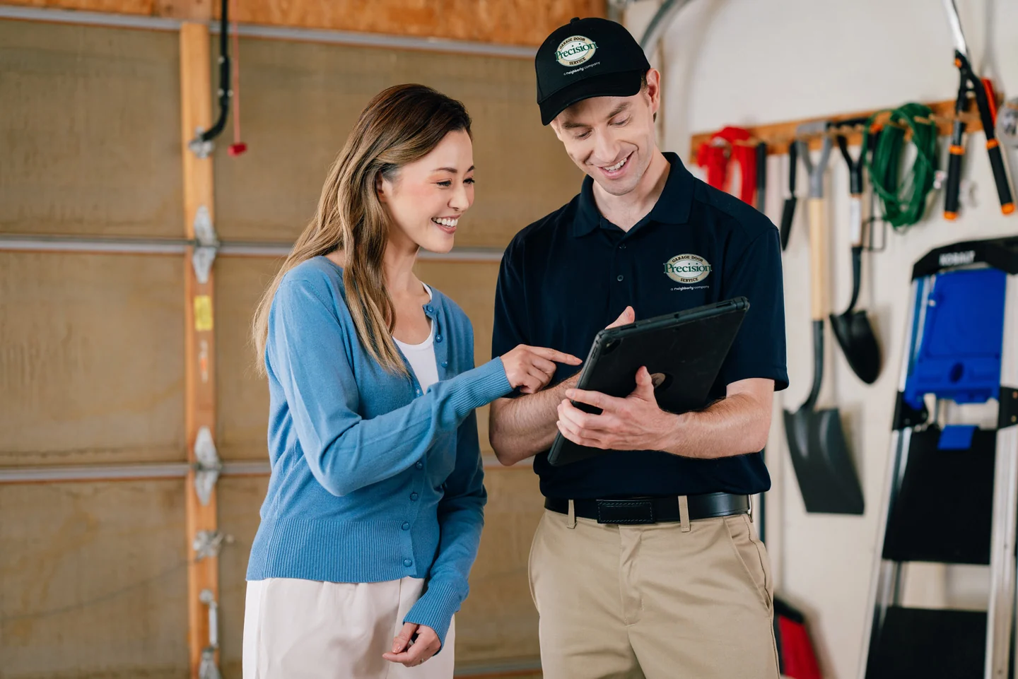 Garage door repair tech reviewing document with a customer