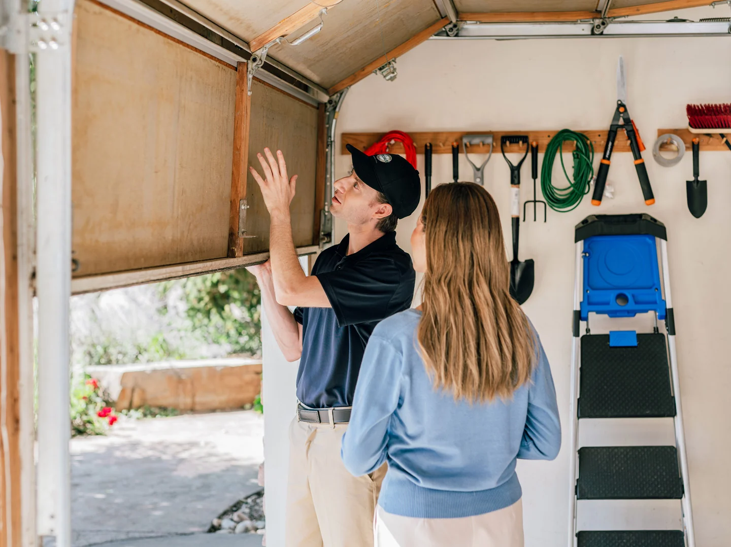 Garage door repair technician inspecting a garage door